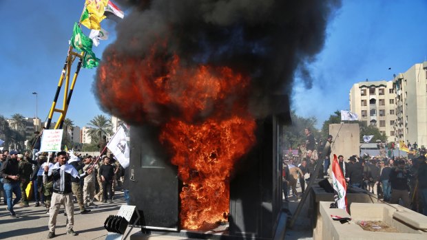 Protesters burn property in front of the US embassy compound, in Baghdad.