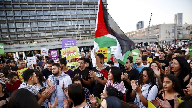 Israeli Arabs hold a Palestinian flag during a protest against the Jewish nation bill in Tel Aviv on Saturday.