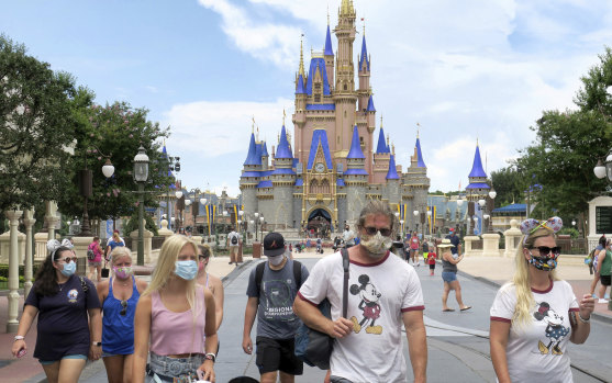 Guests wear masks as required at the Magic Kingdom at Walt Disney World in Florida. 