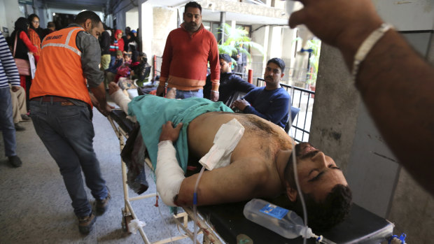 A person injured in a grenade attack is carried for treatment to a government medical hospital in Jammu on Thursday.