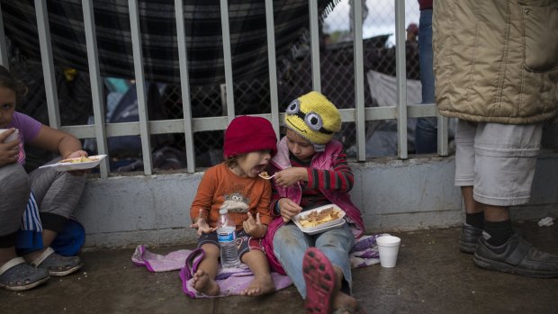 Merary Alejandra feeds her three-year-old sister Britany Sofia, outside a migrant shelter in Tijuana on Thursday.