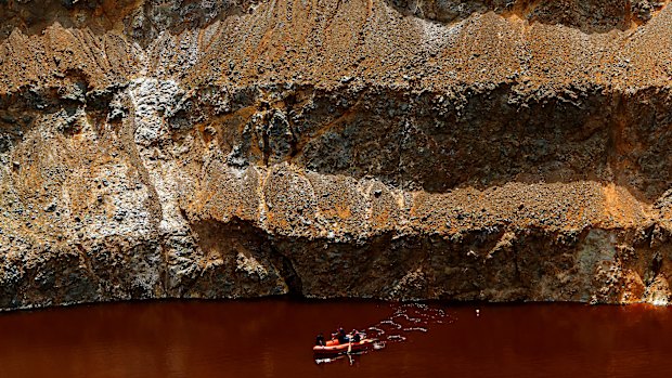 Rescue crews search for three bodies in suitcases dumped in a man-made mining lake.