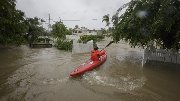 A local resident is seen kayaking in flood waters at her home in Hermit Park Townsville on Sunday.