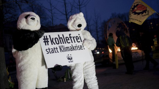 Protesters hold a poster before the meeting of a panel of experts on the exit of the use of  coal in Germany on Friday.