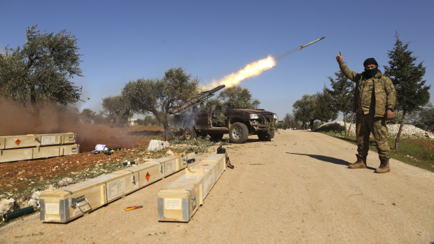Rebel fighters fire a missile towards Syrian government positions in the province of Idlib.