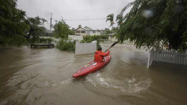 A local resident is seen kayaking in flood waters at her home in Hermit Park Townsville in February.