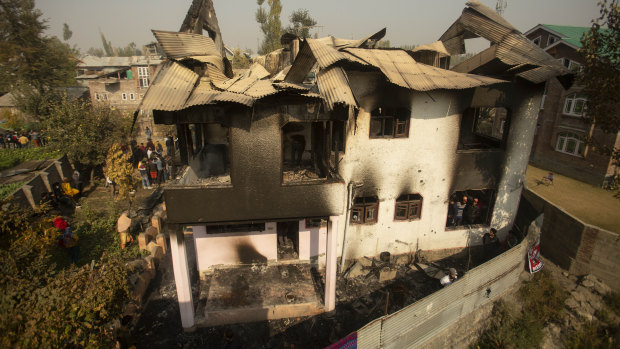 Kashmiris assemble near a damaged house after a gun battle in Srinagar on Wednesday.