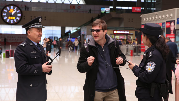 Reporter Paul Mozur,tries on a pair of facial recognition glasses in a train station in Zhengzhou, China.
