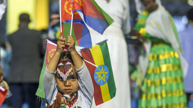 A child holds Ethiopian and Eritrean flags in Addis Ababa, Ethiopia. Official rivals just weeks ago, the leaders of Ethiopia and Eritrea embraced warmly to the roar of a crowd of thousands at a concert celebrating the end of a long state of war. 