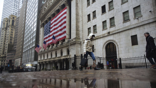 A pedestrian wearing a surgical mask and gloves walks past the New York Stock Exchange on March 19.