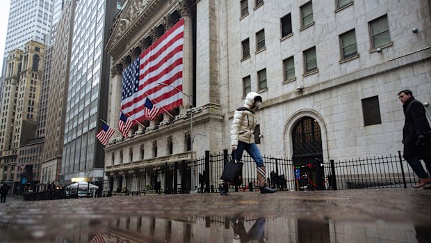 A pedestrian wearing a surgical mask and gloves walks past the New York Stock Exchange on March 19.