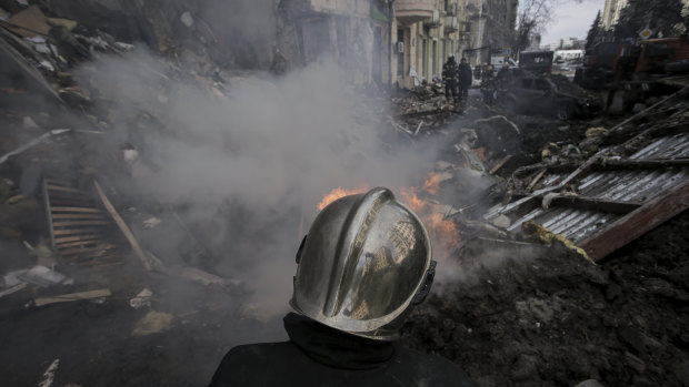 Firefighters extinguish a fire in an apartment building after a Russian rocket attack in Kharkiv.
