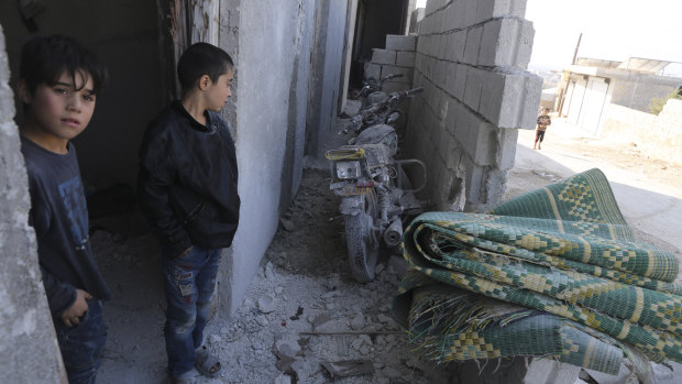 Kids stand by their damaged home in the village of Barisha, in Idlib province, Syria, after an operation by the US military which targeted Abu Bakr al-Baghdadi.