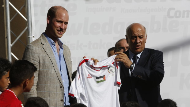 Head of the Palestinian Football Federation, Jibril Rajoub, presents a national team's football jersey to Prince William in Ramallah.