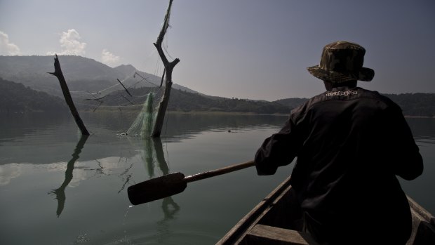 A villager rows a boat at the Doyang reservoir in Wokha district, in the northeastern Indian state of Nagaland.
