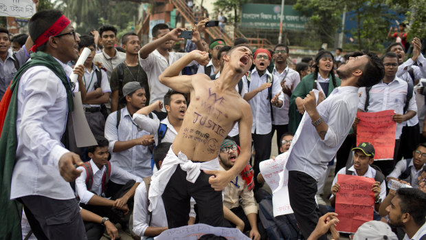 Students shout slogans and block a road during a protest in Dhaka on Saturday.