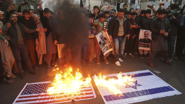 Shiite Muslims burn representations of US and Israeli flags near the US consulate in Lahore, Pakistan in protest over the air strike that killed the Iranian general.