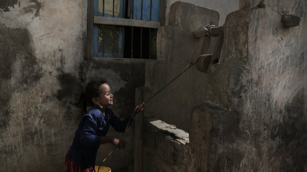 A girl pulls water from a well in the home of Ahmed al-Kawkabani, leader of the southern resistance unit in Hodeida, Yemen.