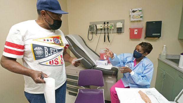 A patient looks at his shot card after receiving the COVID-19 vaccine from a nurse in Clarksdale, Mississippi. 