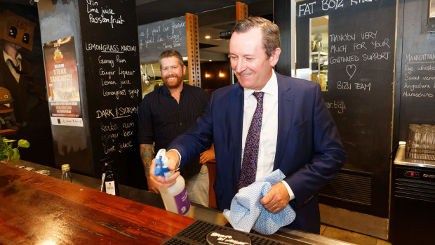 West Australian Premier Mark McGowan cleans the bar with  Bar Bizu owner Jimmy Durante.