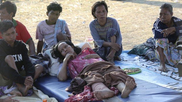 An injured woman lies at a temporary shelter in North Lombok. 