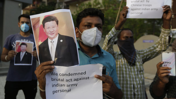 An Indian man holds a photograph of Chinese President Xi Jinping during a protest against China in Ahmedabad, India, this week.
