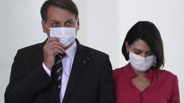 Brazil's President Jair Bolsonaro and his wife Michelle at an event in Brasilia on Wednesday, a day before she tested positive for COVID-19.
