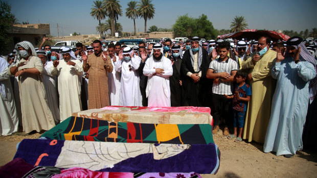 Mourners pray over the coffins of civilians killed by a Katyusha rocket attack near the international airport in Baghdad on Tuesday.