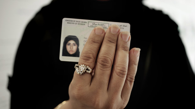 A Saudi woman covering her name holds her new car licence at the Saudi Driving School inside Princess Nora University in Saudi Arabia.
