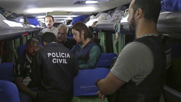 Police interview members of the bus convoy at a parking lot in Laranjeiras do Sul.