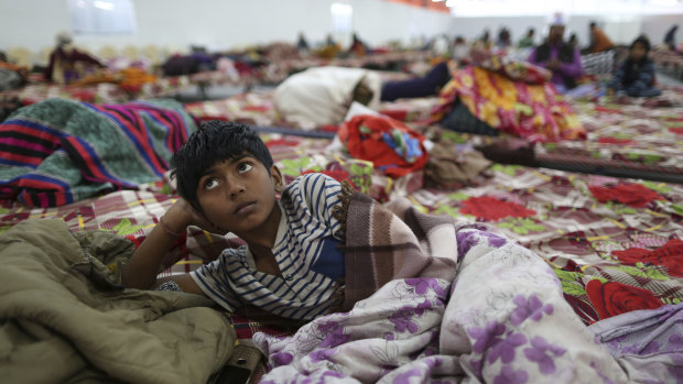 A boy rests in a makeshift night shelter set up for the festival.