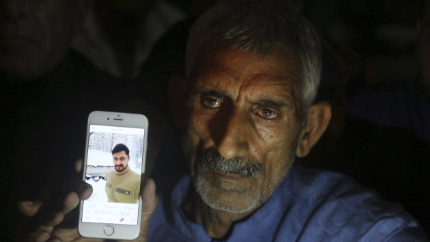 Pakistani man Mohammad Aslam shows a picture of his son Taimoor Aslam, who was one of the people killed at the Kashmir border (Line of Control) on Thursday.