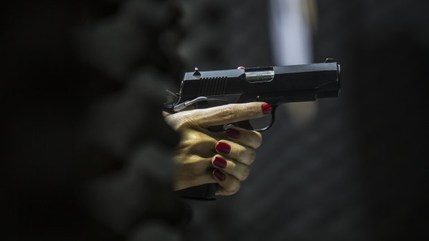 A woman holds a gun at the firing range inside the Colt 45 Shooting Club in Rio de Janeiro.