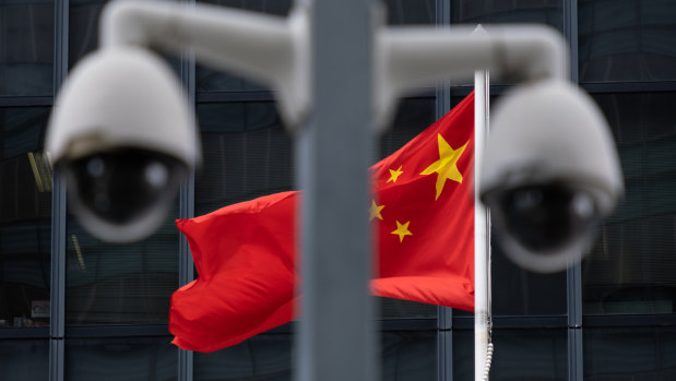 The Chinese flag flies behind a pair of surveillance cameras outside the Central Government Offices in Hong Kong.