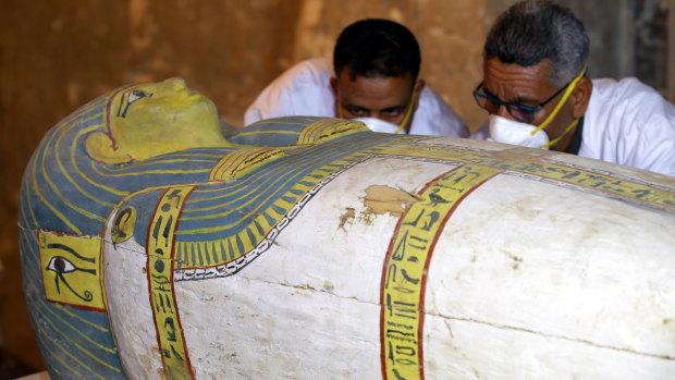 Egyptian archaeologists examine the cover of an intact sarcophagus, inside Tomb TT33 in Luxor, 700 kilometres south of Cairo.