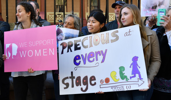 Anti-abortion protesters hold signs during a rally outside NSW Parliament.