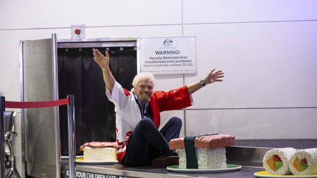 Sir Richard Branson, founder of Virgin Group, arrives on a giant sushi train at the Brisbane-Tokyo announcement.