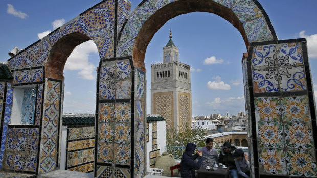 Tunisians take their coffee on a rooftop coffee shop, in the old city of Tunis, Tunisia.