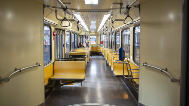 Commuters ride a deserted tram carriage in Milan.