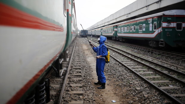 A volunteer sprays disinfectant on a train, in an effort to prevent coronavirus, at the Kamlapur Railway Station in Dhaka, Bangladesh in March.