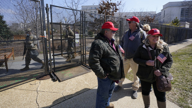 Supporters of former President Donald Trump, John Carson, of California, left, Karyn Carson, right, stand outside of security fencing around the US Capitol.