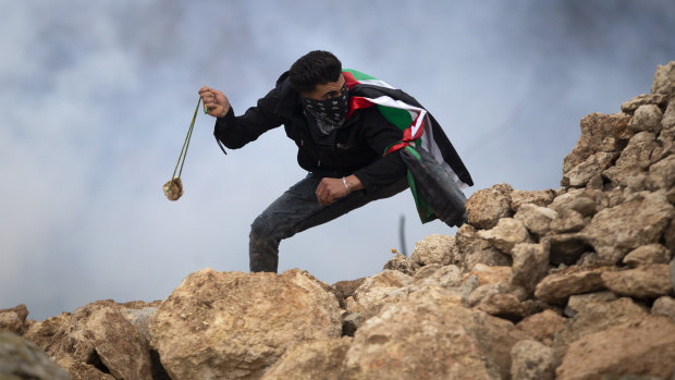 A Palestinian demonstrator uses a sling to hurl stones at Israeli soldiers during a protest against Israeli settlements, in the village of Mughayer, near the West Bank city of Ramallah on Friday.