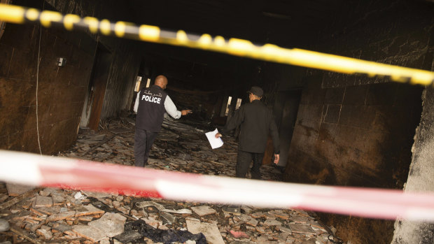 Two police officers investigate the building of Libya's high national elections commission in Tripoli after a suicide bombing on Wednesday.