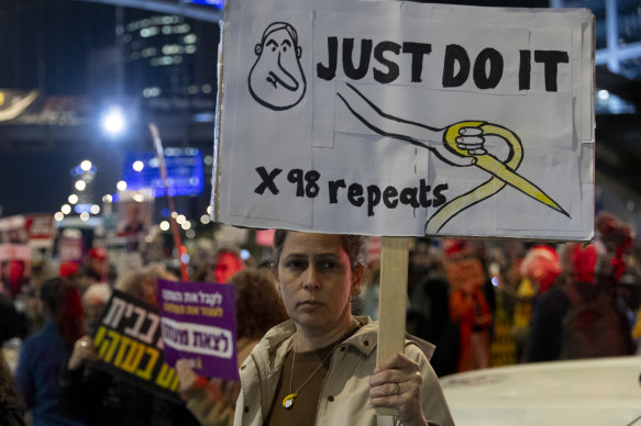 A protester in Tel Aviv holds a sign during a demonstration calling on the Israeli government to secure the return of hostages held by Hamas.