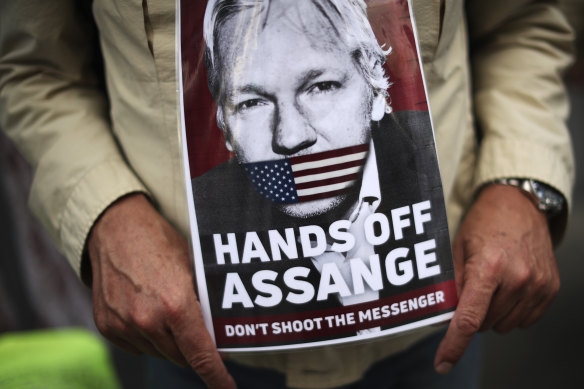 A man holds a photograph of WikiLeaks founder Julian Assange during a protest in Brussels demanding he be freed.
