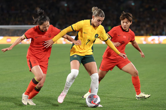 Steph Catley: cool, calm and collected while under the kosh from two Chinese players.