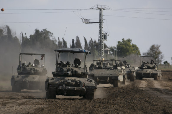 Israeli tanks and armoured personnel carriers move along the border with the Gaza Strip.