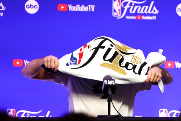 Luka Doncic draps an NBA Finals towel over his head during media day on Thursday AEST.
