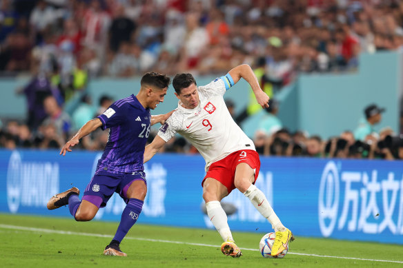 Robert Lewandowski of Poland battles for possession with Nahuel Molina of Argentina.