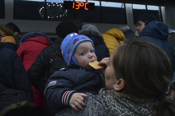 A woman holds her child as other evacuees from Kherson flee the city. 